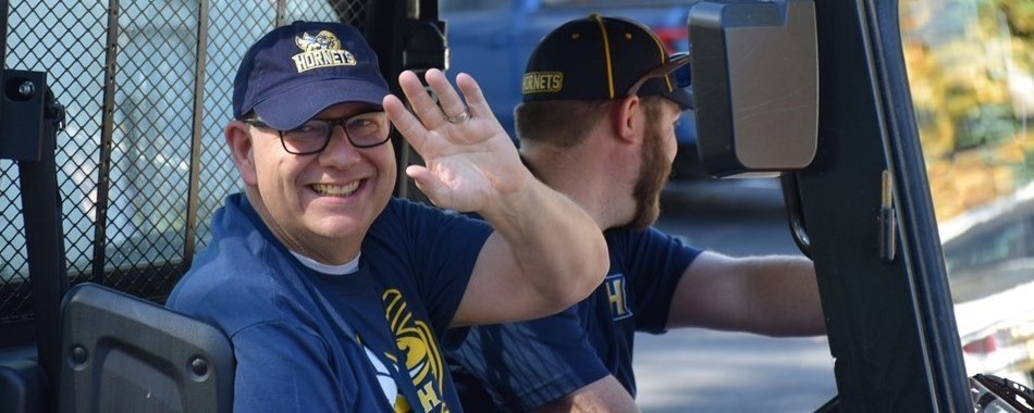 Man in tractor waving at the Homecoming Parade