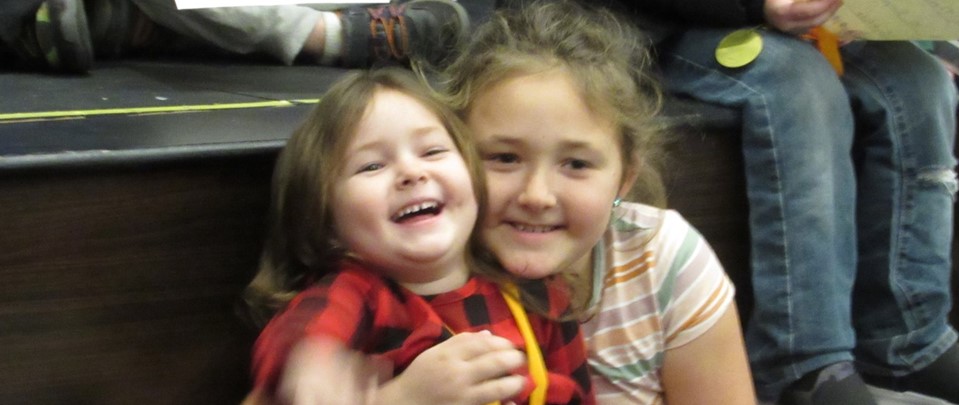 sisters in an elementary school assembly
