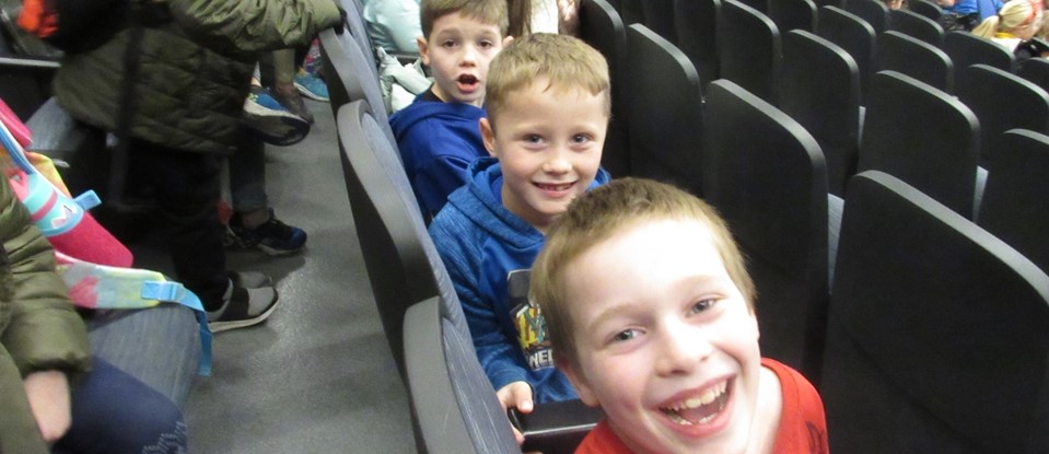 smiling boys in elementary assembly