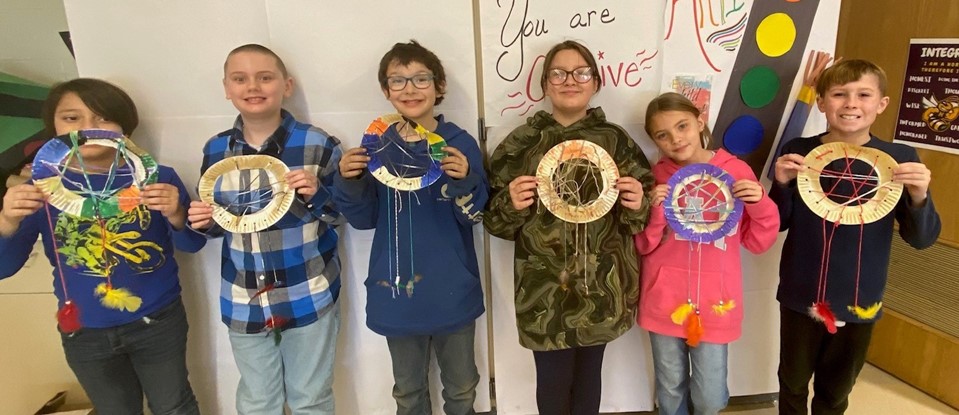 Fourth grade students showing off their dream catchers they made in art class 