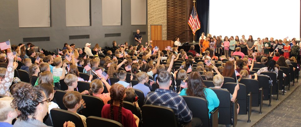 students waiving flags during Memorial Day program